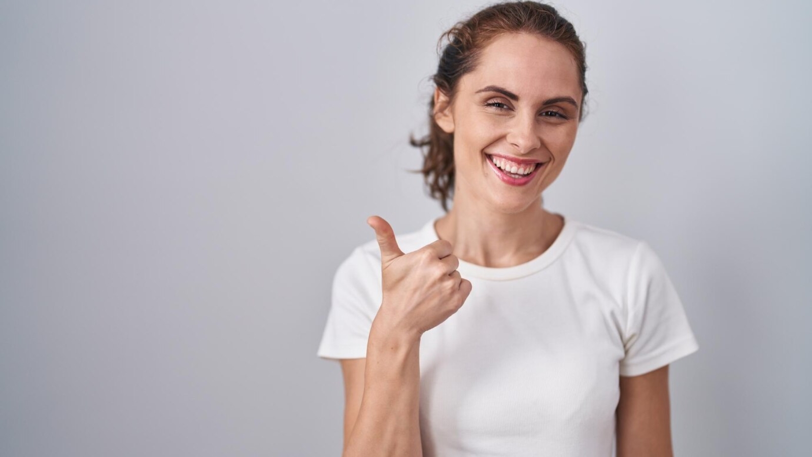 beautiful-brunette-woman-standing-isolated-background-doing-happy-thumbs-up-gesture-with-hand-approving-expression-looking-camera-showing-success_839833-34348