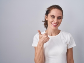 beautiful-brunette-woman-standing-isolated-background-doing-happy-thumbs-up-gesture-with-hand-approving-expression-looking-camera-showing-success_839833-34348